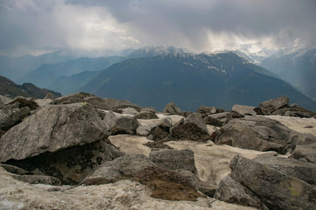 Breathtaking view of snow-capped mountain peaks under a cloudy sky.