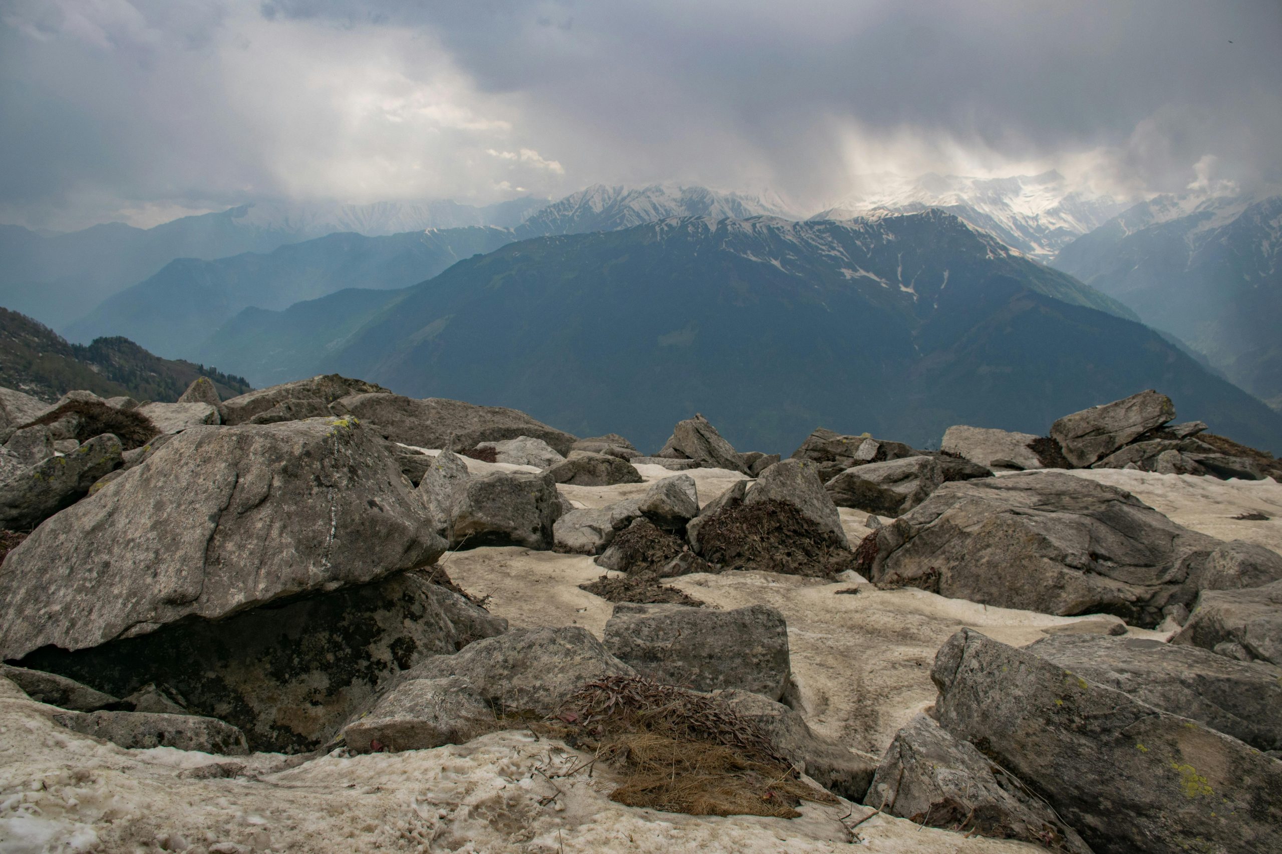 Breathtaking view of snow-capped mountain peaks under a cloudy sky.